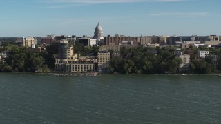 DX0002_160_027 - 5.7K aerial stock footage focus on the capitol dome while flying past a lakeside hotel in Madison, Wisconsin