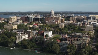 DX0002_160_032 - 5.7K aerial stock footage fly toward the capitol dome from lakeside apartment buildings in Madison, Wisconsin