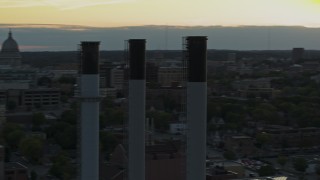 DX0002_161_030 - 5.7K aerial stock footage passing the capitol dome at sunset, reveal and orbit smoke stacks, Madison, Wisconsin