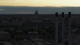 DX0002_162_004 - 5.7K aerial stock footage flyby smoke stacks to approach the capitol dome at sunset, Madison, Wisconsin