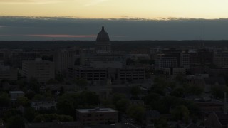 DX0002_162_005 - 5.7K aerial stock footage reveal smoke stacks while flying away from the capitol dome at sunset, Madison, Wisconsin