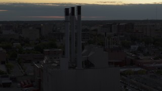 DX0002_162_010 - 5.7K aerial stock footage of approach and orbit power plant smoke stacks at twilight, Madison, Wisconsin