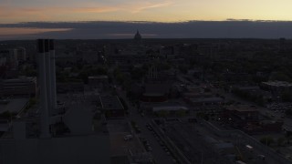 DX0002_162_015 - 5.7K aerial stock footage flyby and away from the capitol dome and power plant smoke stacks at twilight, Madison, Wisconsin