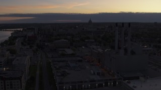 DX0002_162_016 - 5.7K aerial stock footage the capitol dome seen from near power plant smoke stacks at twilight, Madison, Wisconsin