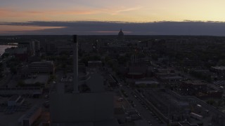 DX0002_162_017 - 5.7K aerial stock footage the capitol dome seen while passing power plant smoke stacks at twilight, Madison, Wisconsin