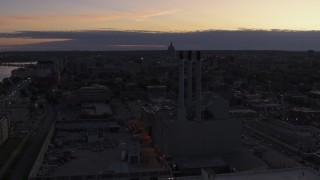 DX0002_162_018 - 5.7K aerial stock footage focus on capitol dome while passing power plant smoke stacks at twilight, Madison, Wisconsin