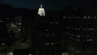 DX0002_162_041 - 5.7K aerial stock footage view of capitol dome while descending by building at night, Madison, Wisconsin