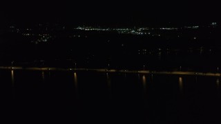 DX0002_162_056 - 5.7K aerial stock footage of light traffic on a causeway on the lake at night, Madison, Wisconsin