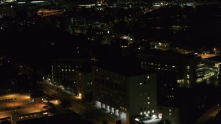 DX0002_163_020 - 5.7K aerial stock footage orbit a hospital complex and flyby parking garage at night, Madison, Wisconsin