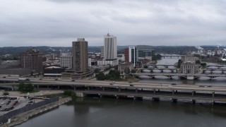 DX0002_164_001 - 5.7K aerial stock footage of an apartment high-rise and office buildings near bridges over the river, Downtown Cedar Rapids, Iowa