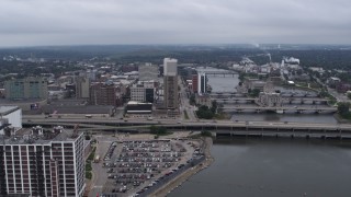 DX0002_164_003 - 5.7K aerial stock footage slow approach to apartment high-rise and office buildings near bridges and river, Downtown Cedar Rapids, Iowa