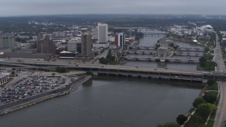 DX0002_164_009 - 5.7K aerial stock footage fly away from and flyby bridges spanning the river beside Downtown Cedar Rapids, Iowa