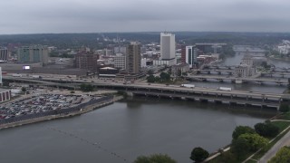 DX0002_164_012 - 5.7K aerial stock footage fly toward apartment high-rise and bridges spanning the river, Downtown Cedar Rapids, Iowa
