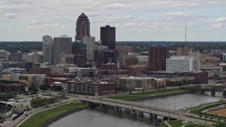 DX0002_165_034 - 5.7K aerial stock footage of flying by a Cedar River bridge with view of skyline, Downtown Des Moines, Iowa