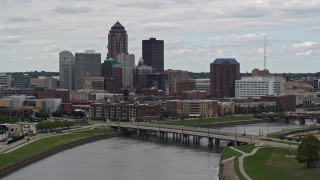 DX0002_165_035 - 5.7K aerial stock footage of descending past a Cedar River bridge with view of skyline, Downtown Des Moines, Iowa