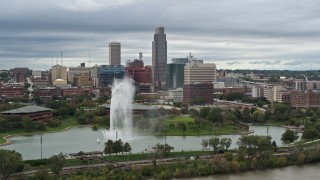 DX0002_169_030 - 5.7K aerial stock footage of the city's skyline while flying by a park fountain, Downtown Omaha, Nebraska
