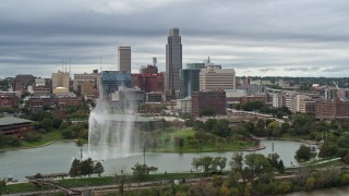 DX0002_169_031 - 5.7K aerial stock footage of the city's skyline while passing a park fountain, Downtown Omaha, Nebraska