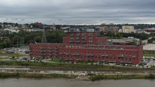 DX0002_169_033 - 5.7K aerial stock footage descend and orbit a riverfront apartment complex, Downtown Omaha, Nebraska
