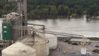 DX0002_170_007 - 5.7K aerial stock footage orbit storage tanks and grain elevator by river, Council Bluffs, Iowa