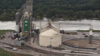 DX0002_170_008 - 5.7K aerial stock footage a reverse view of storage tanks and grain elevator by river, Council Bluffs, Iowa