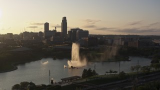 DX0002_172_008 - 5.7K aerial stock footage ascending away from a fountain with view of skyline at sunset, Downtown Omaha, Nebraska