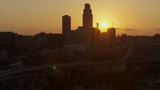 DX0002_172_026 - 5.7K aerial stock footage slowly circle skyscraper and skyline with setting sun in background, Downtown Omaha, Nebraska
