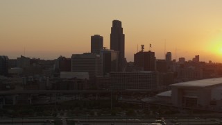 DX0002_172_030 - 5.7K aerial stock footage slowly fly away from and orbit skyscraper and skyline, setting sun in background, Downtown Omaha, Nebraska