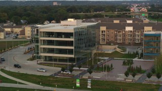 DX0002_172_033 - 5.7K aerial stock footage of orbiting a modern office building at sunset in Council Bluffs, Iowa