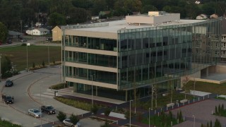 DX0002_172_035 - 5.7K aerial stock footage of a reverse view of a modern office building at sunset in Council Bluffs, Iowa
