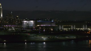 DX0002_173_029 - 5.7K aerial stock footage approach arena and convention center complex from river at night, Downtown Omaha, Nebraska