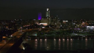 DX0002_173_034 - 5.7K aerial stock footage flyby the city's skyline at night, reveal bridge spanning river, Downtown Omaha, Nebraska