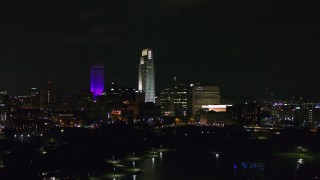 DX0002_173_039 - 5.7K aerial stock footage of slowly flying by tall skyscrapers at night, Downtown Omaha, Nebraska