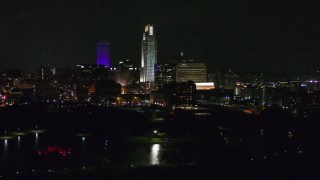 DX0002_173_040 - 5.7K aerial stock footage of slowly passing tall skyscrapers at night, Downtown Omaha, Nebraska