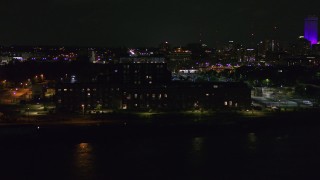 DX0002_173_043 - 5.7K aerial stock footage of flying by an apartment complex at night, Downtown Omaha, Nebraska