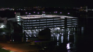DX0002_173_044 - 5.7K aerial stock footage a close orbit of a parking garage at night in Council Bluffs, Iowa