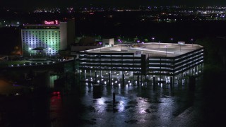 DX0002_173_046 - 5.7K stock footage aerial video orbit and fly away from parking garage and the hotel and casino at night in Council Bluffs, Iowa