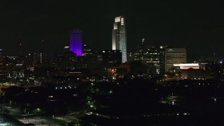 DX0002_173_059 - 5.7K aerial stock footage towering skyscrapers seen from the park at night, Downtown Omaha, Nebraska