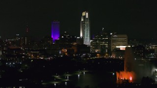 DX0002_173_064 - 5.7K aerial stock footage fly away from city's skyscrapers and the park fountain at night, Downtown Omaha, Nebraska