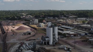 DX0002_175_032 - 5.7K aerial stock footage orbit a train passing warehouse and industrial buildings in Sioux City, Iowa