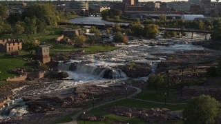 DX0002_176_007 - 5.7K aerial stock footage descending by the waterfalls at Falls Park at sunset in Sioux Falls, South Dakota