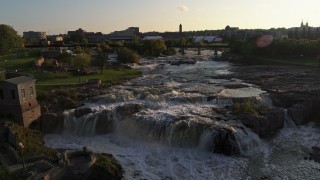 DX0002_176_021 - 5.7K aerial stock footage reverse view of waterfalls on Big Sioux River at sunset in Sioux Falls, South Dakota