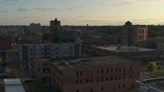 DX0002_176_024 - 5.7K aerial stock footage stationary view of apartment buildings, approach the Old Courthouse Museum at sunset in Downtown Sioux Falls, South Dakota