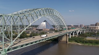 DX0002_178_022 - 5.7K aerial stock footage flying by cars crossing the bridge to Memphis, Tennessee, reveal Memphis Pyramid