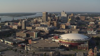 DX0002_180_022 - 5.7K aerial stock footage of ascend away from FedEx Forum arena and city skyline at sunset, Downtown Memphis, Tennessee