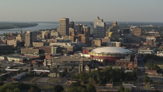 DX0002_180_033 - 5.7K aerial stock footage flying away from FedEx Forum arena while focused on the skyline at sunset, Downtown Memphis, Tennessee