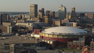 DX0002_180_037 - 5.7K aerial stock footage descend toward FedEx Forum arena at sunset, skyline in background, Downtown Memphis, Tennessee