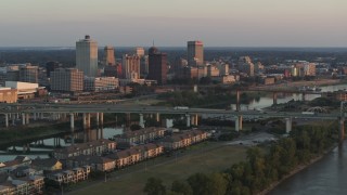 DX0002_181_010 - 5.7K aerial stock footage of the city's skyline behind the bridge and the river at sunset, Downtown Memphis, Tennessee