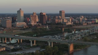 DX0002_181_014 - 5.7K aerial stock footage flyby the city's skyline behind the bridge and the river at sunset, Downtown Memphis, Tennessee
