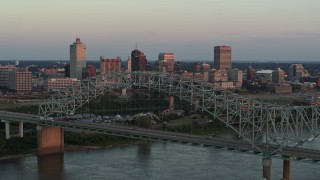 DX0002_181_022 - 5.7K aerial stock footage of ascending past the the bridge at sunset for a view of Downtown Memphis, Tennessee