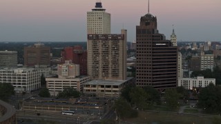 DX0002_181_029 - 5.7K aerial stock footage flying by apartment and office high-rises at sunset in Downtown Memphis, Tennessee